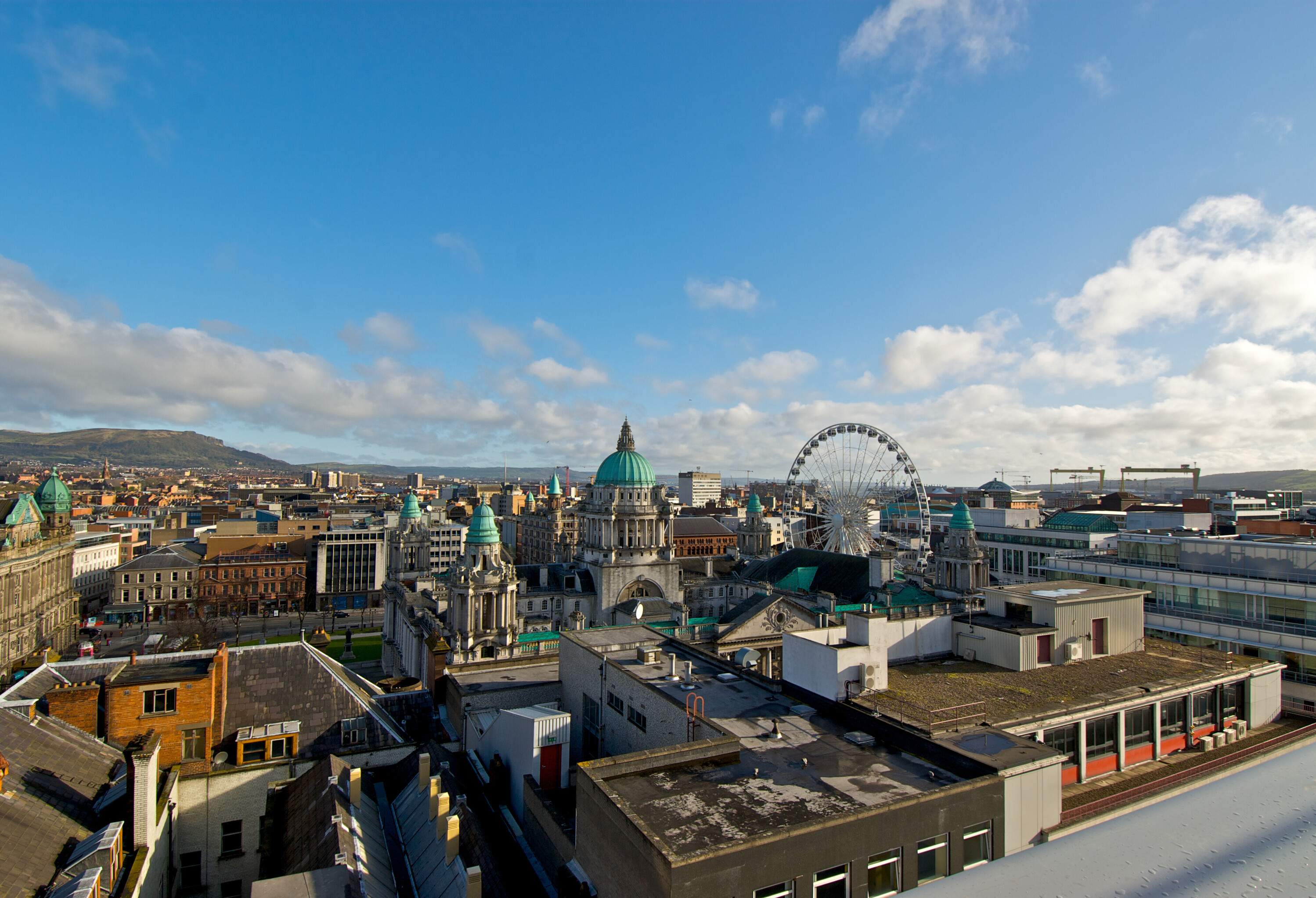 A stunning cityscape with a towering ferris wheel in the background, a majestic dome-capped structure in the centre, and a bustling urban metropolis stretching out towards the horizon.