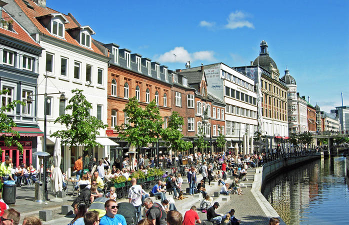 many people sitting at Aarhus Canal in the Midtbyen district