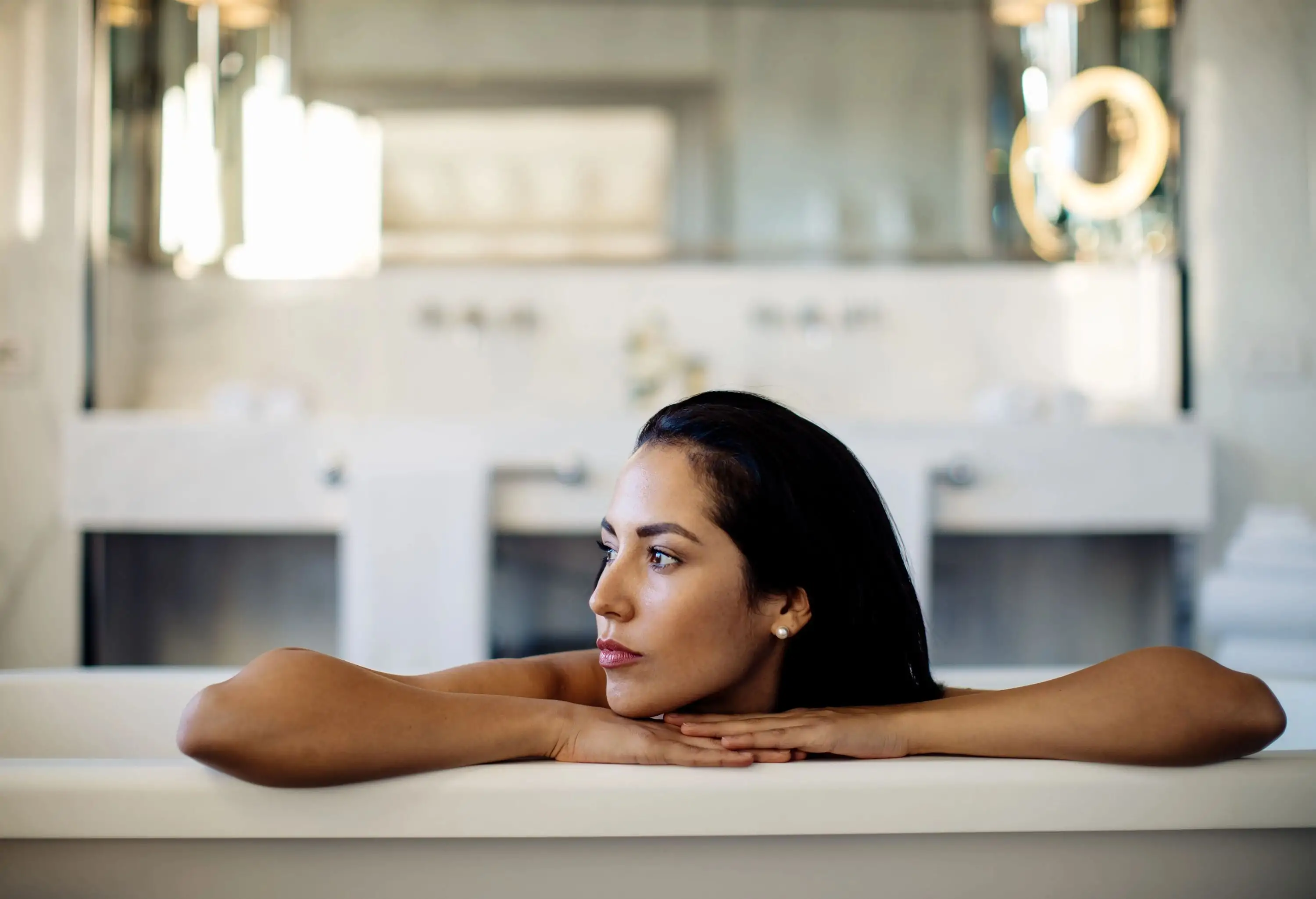 Woman relaxing in bathtub in suite