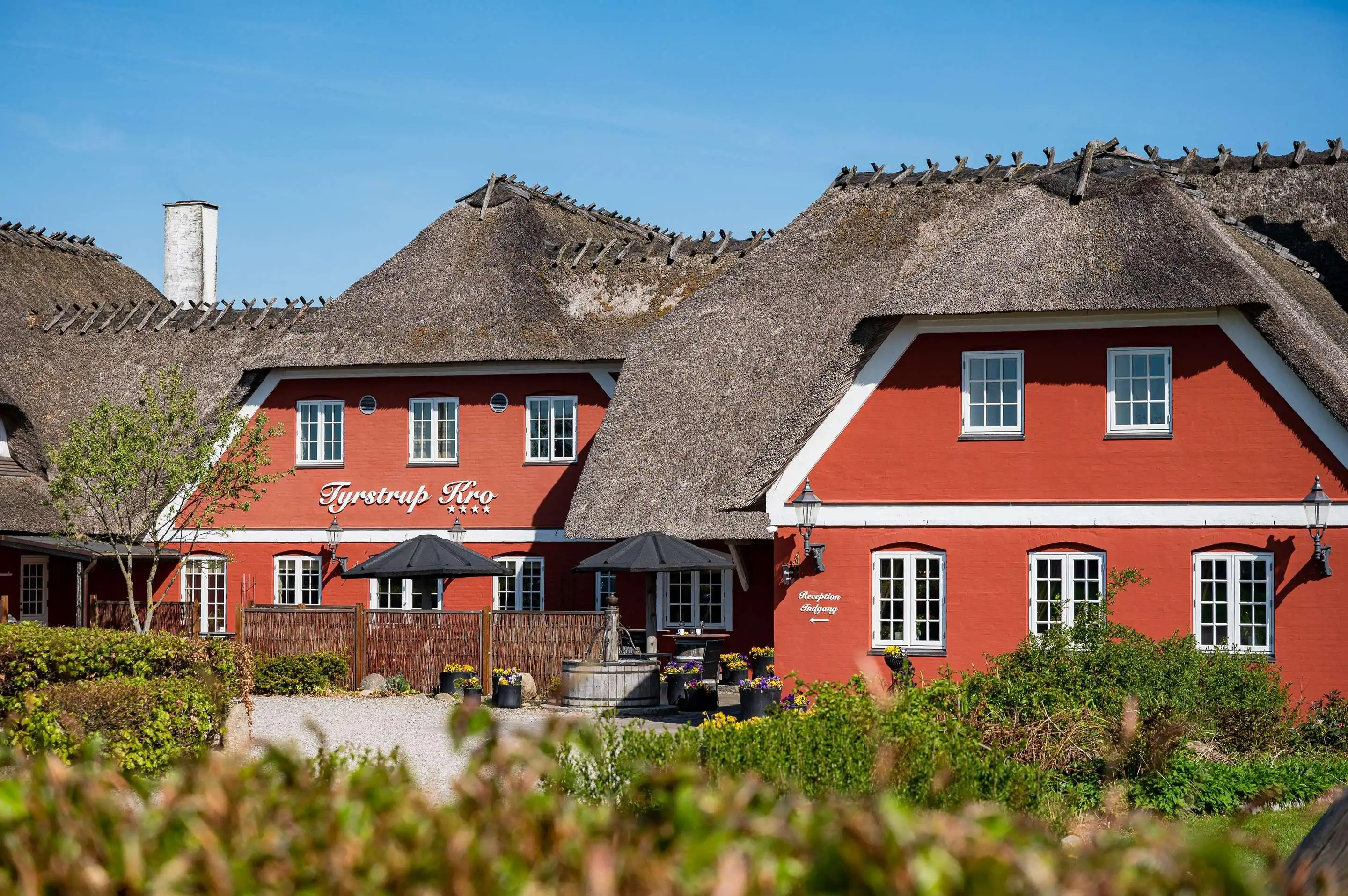 View of thatched building with red walls on a sunny summer day