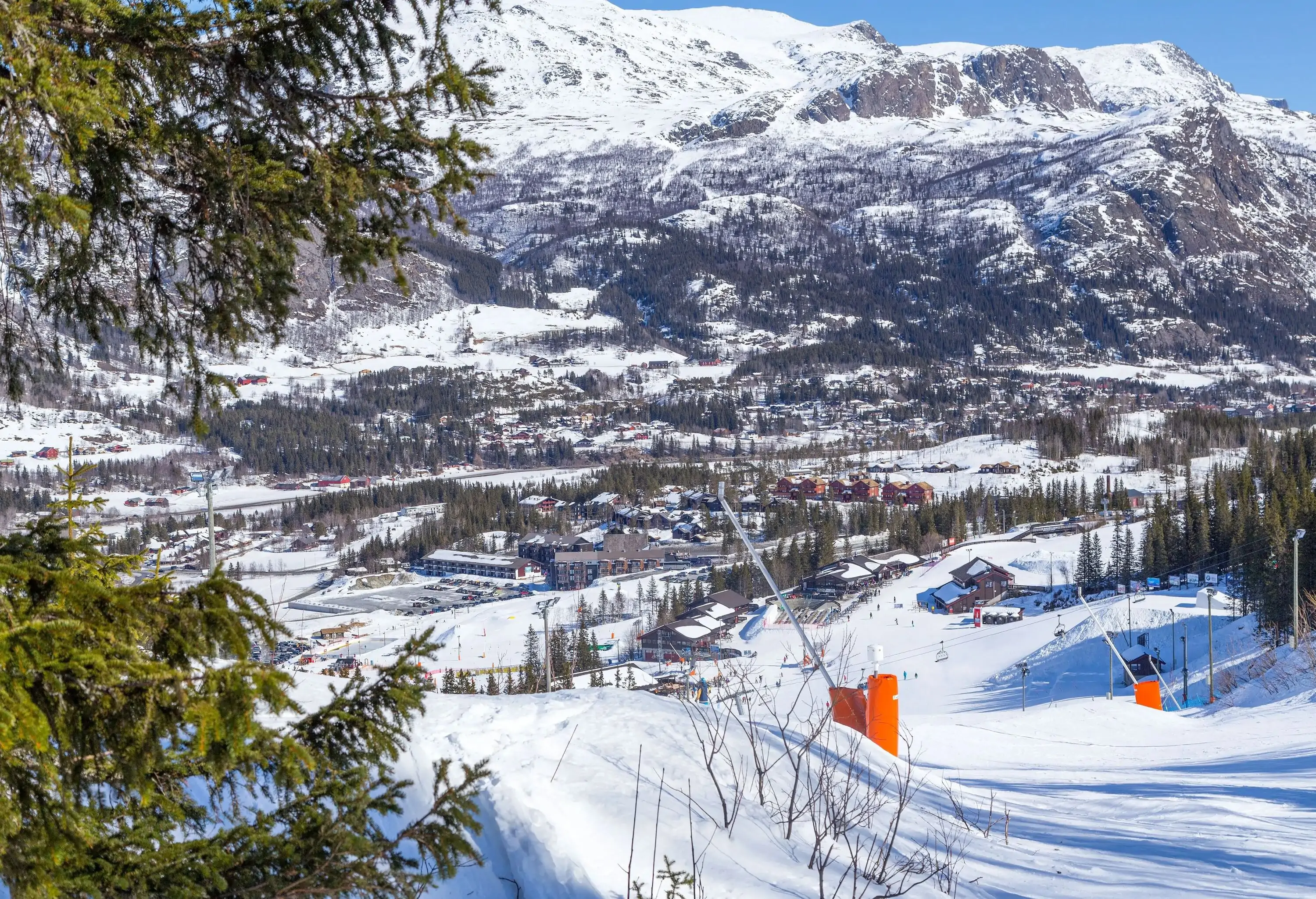 A ski slope with views of a snow-covered ski village below.