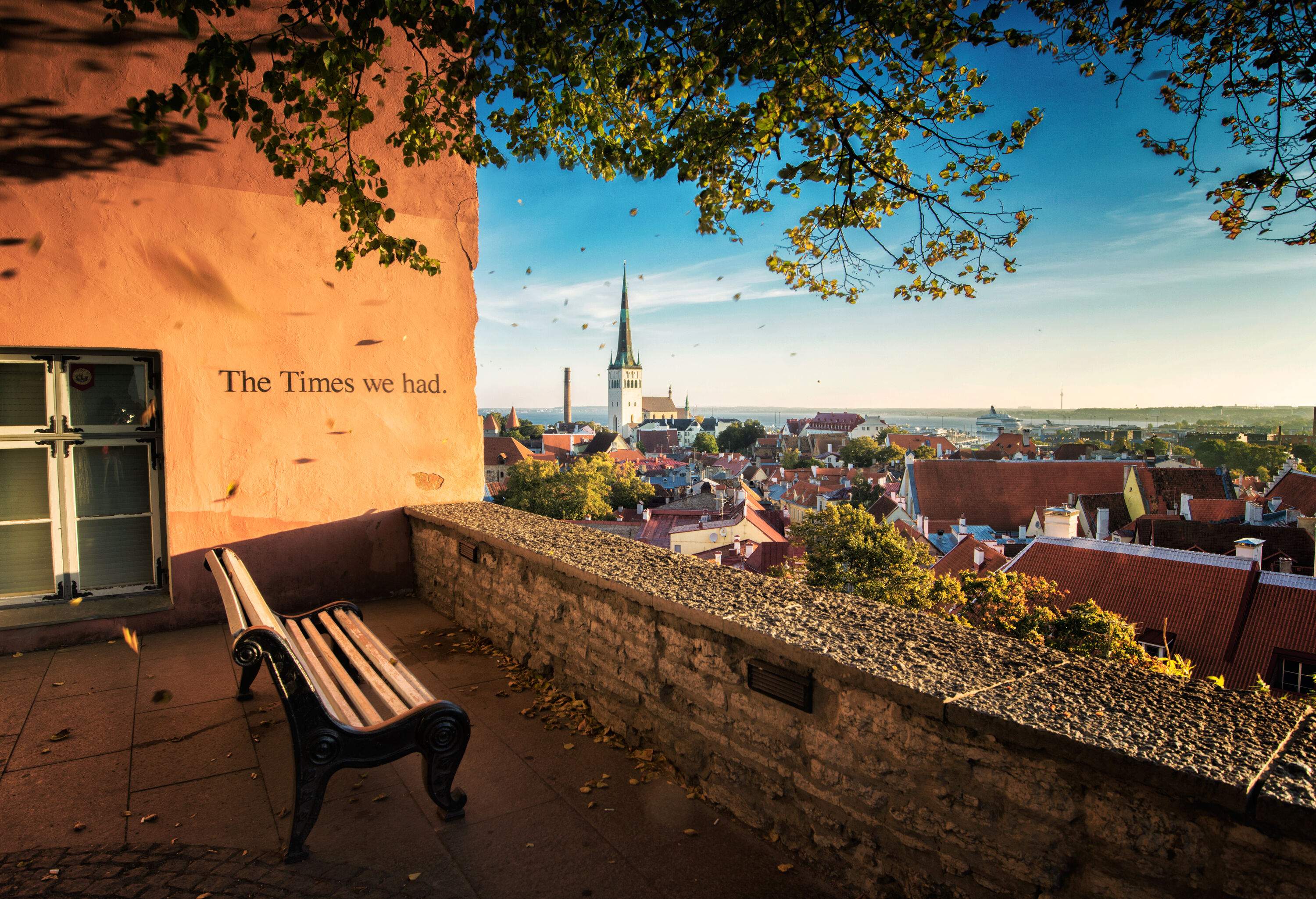 A bench on a terrace beside a wall with words that reads 