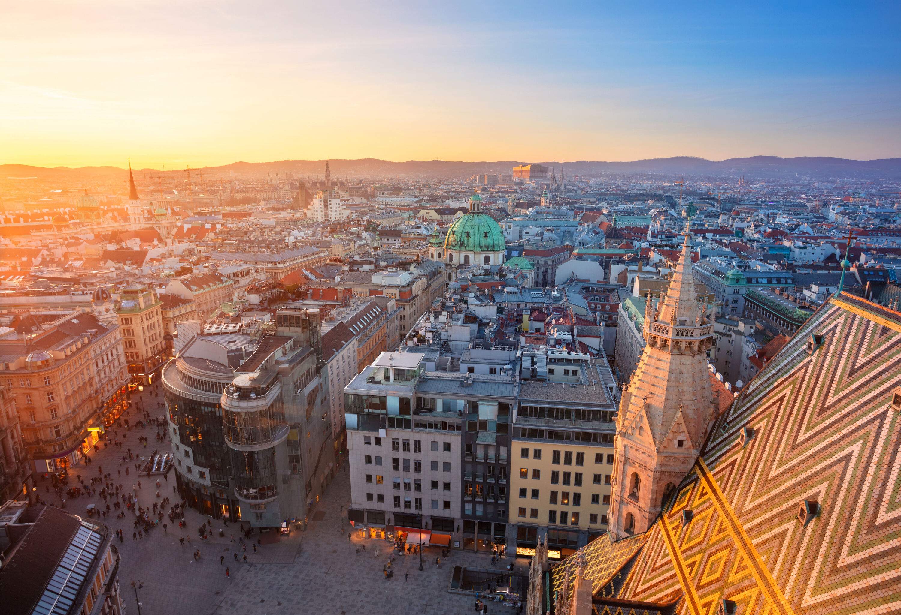 A sprawling cityscape unfolds, with a bustling forked street teeming with pedestrians and flanked by an array of diverse and intriguing buildings.