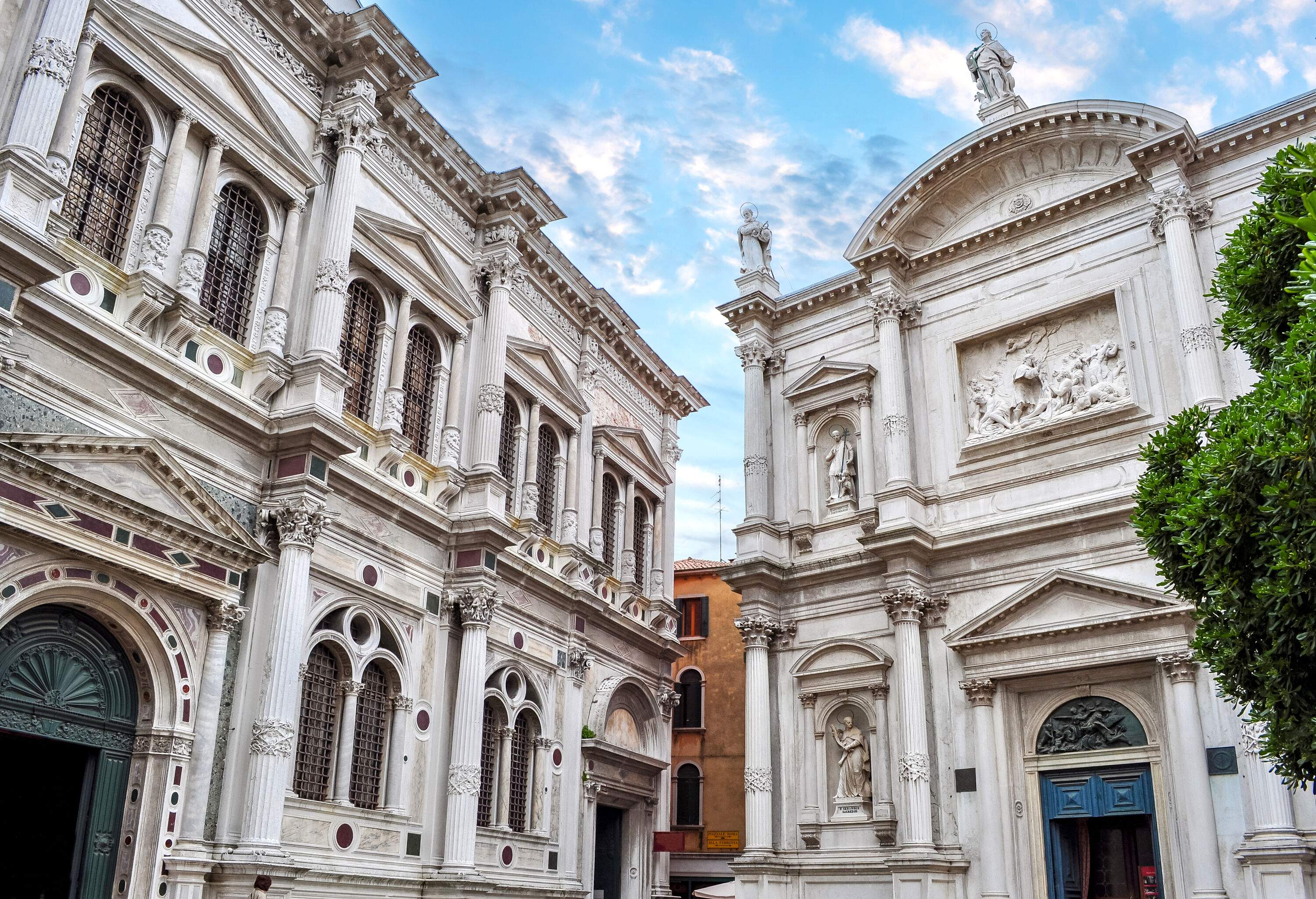 An ornate museum building stands beside a Roman Catholic church.