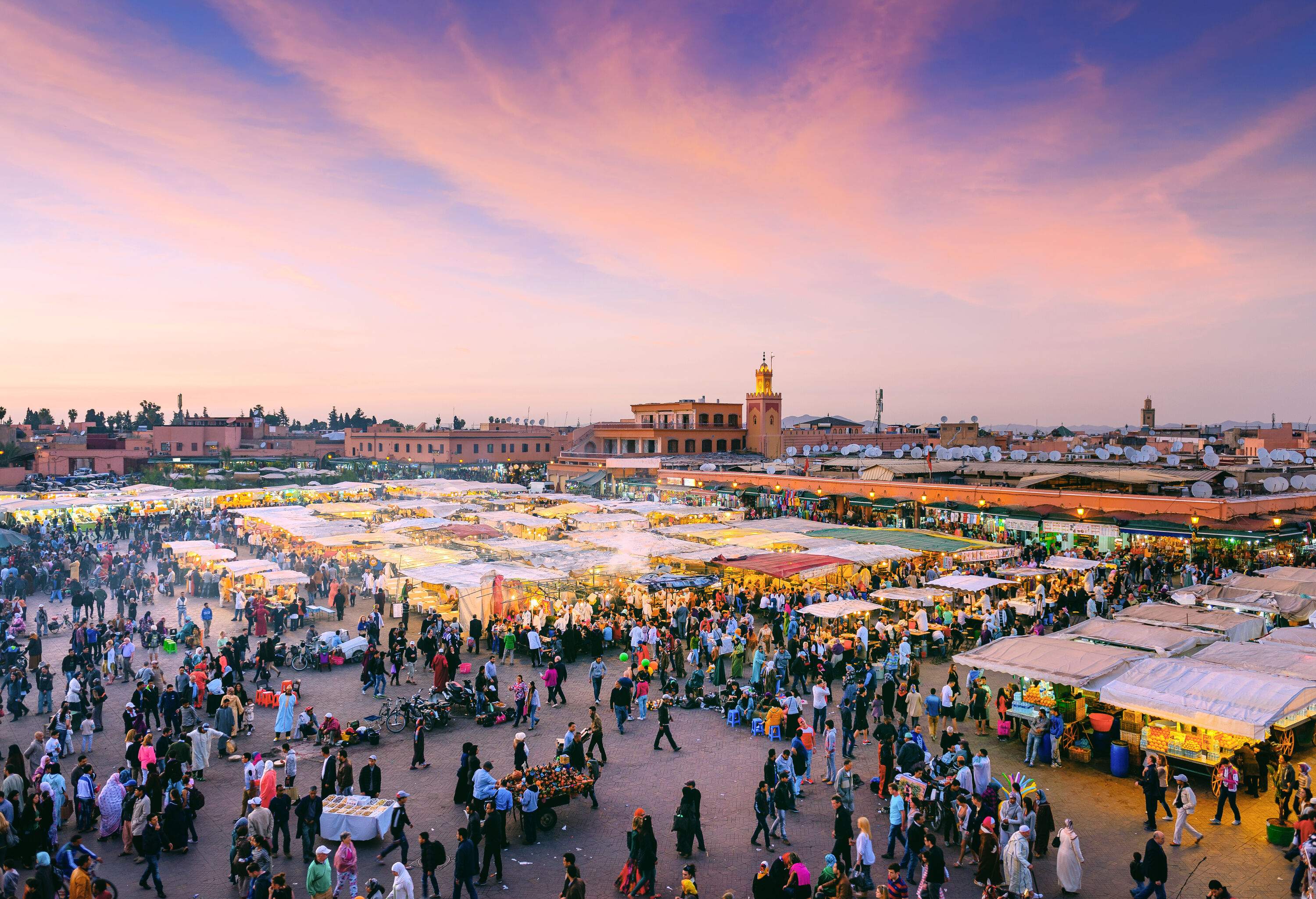 The bustling Jemaa el-Fna Square packed with people and market vendors.