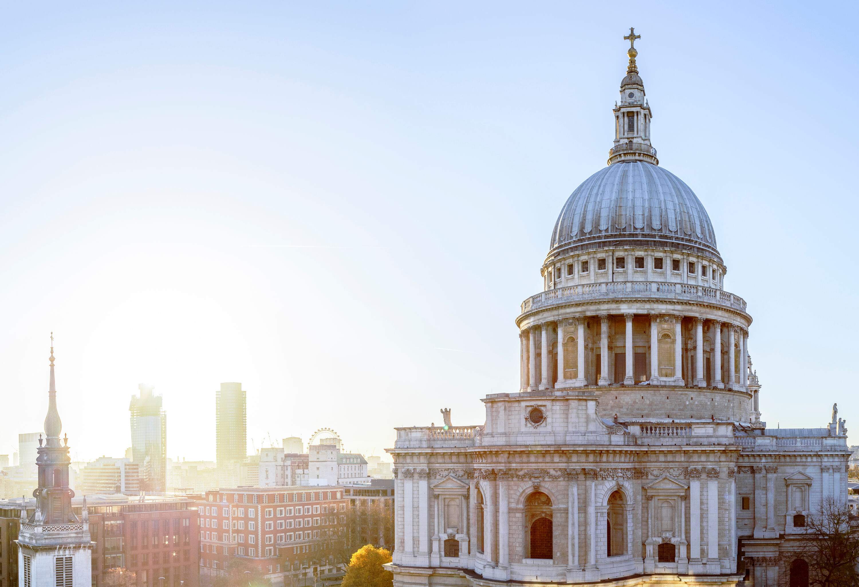 A sunlit cathedral's dome dominates the city's other tall buildings.