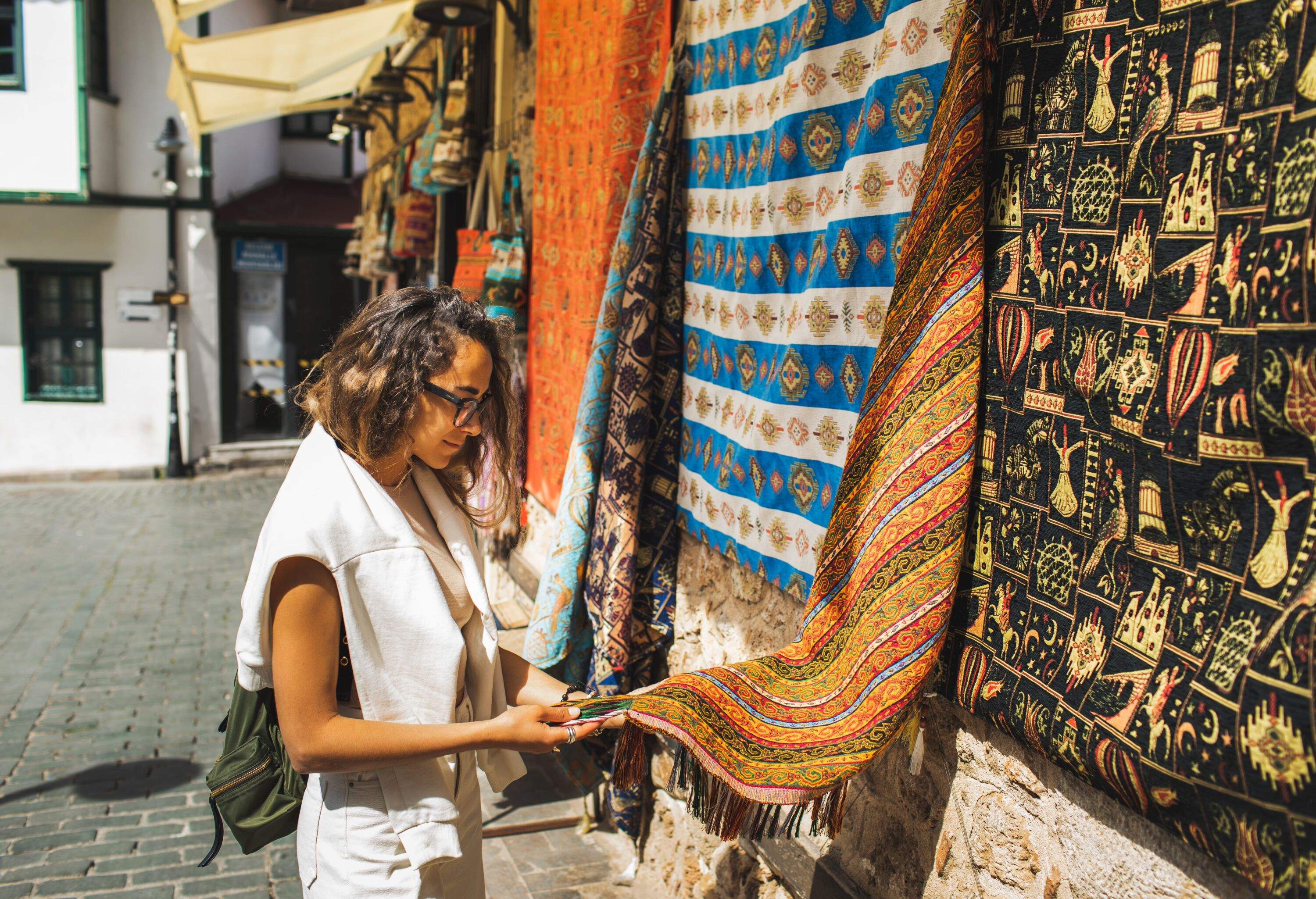 Woman shopping for Beautiful vibrant handicraft carpet in middle eastern style.