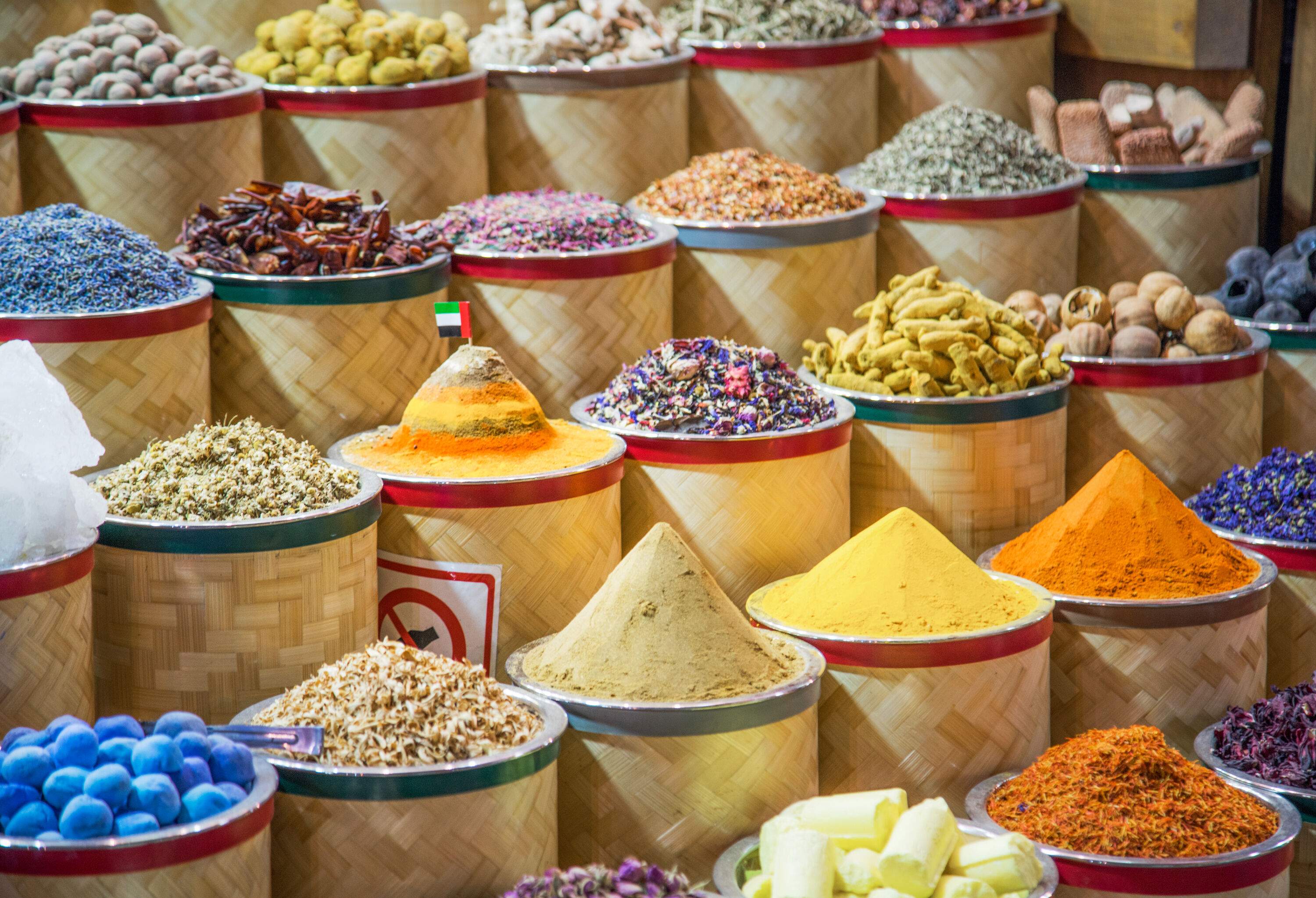 Rows of colourful and different spices on wooden baskets.