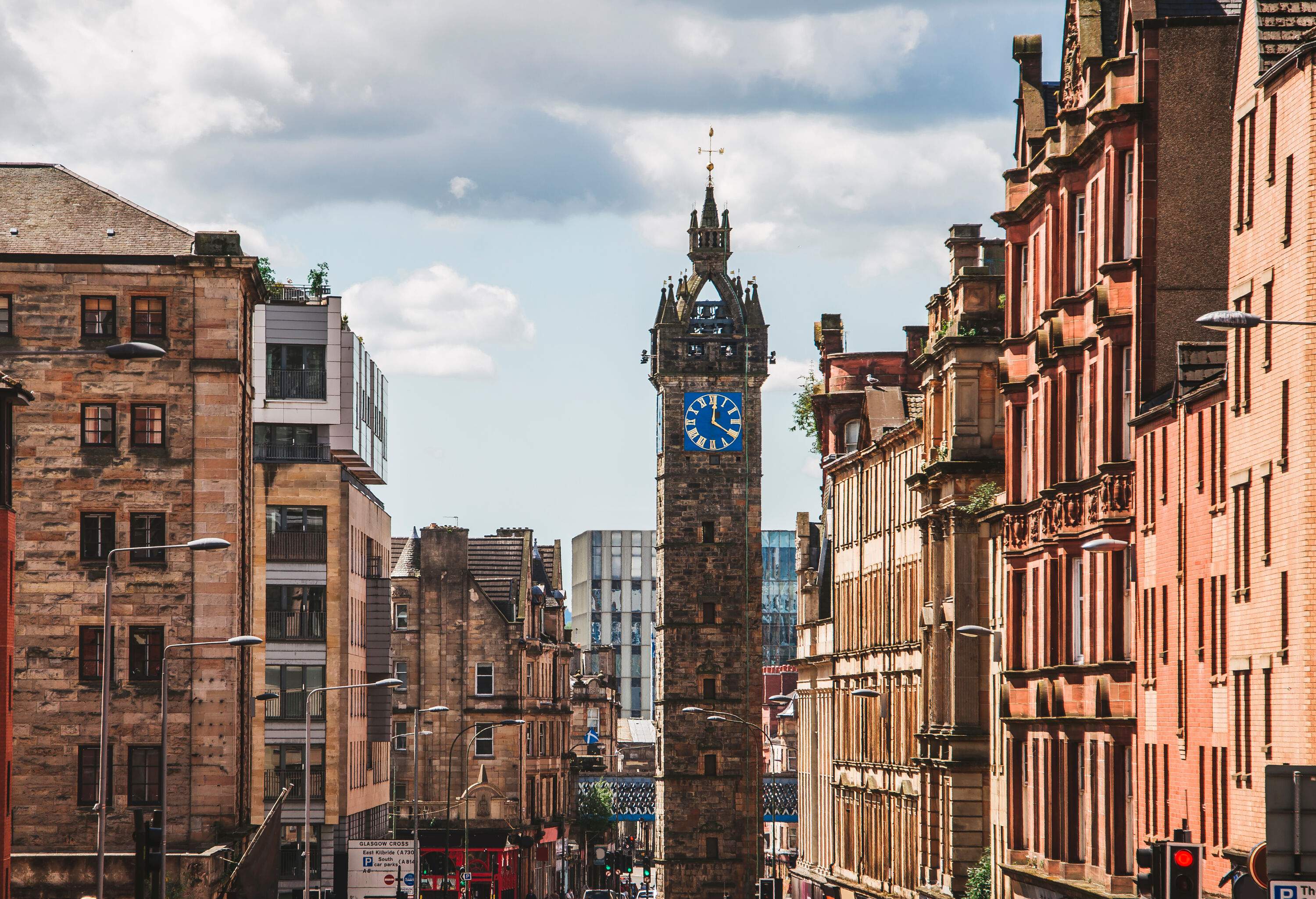 A clock tower amid tall, historic brick structures.