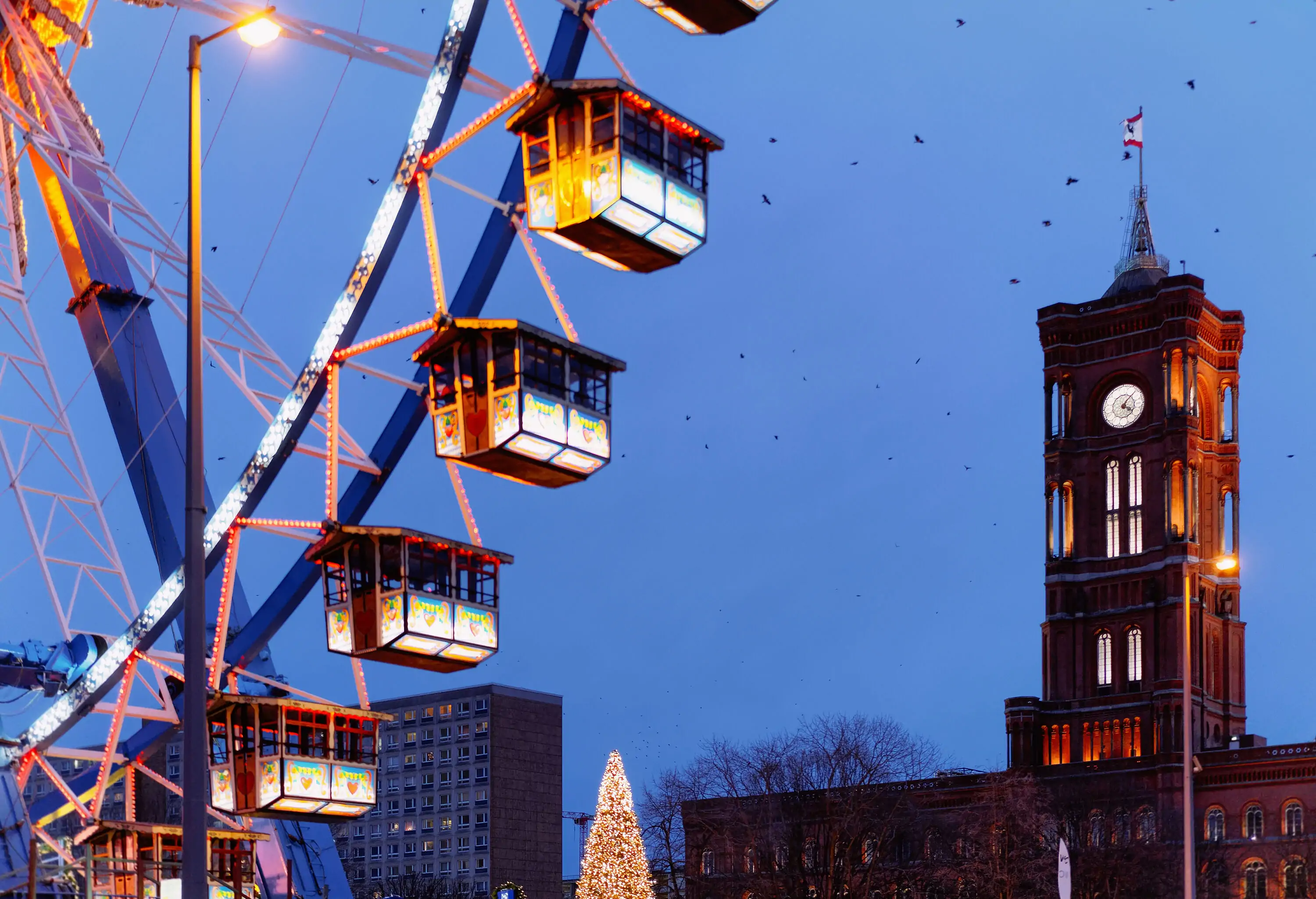 Ferris Wheel and Town Hall at Night Christmas Market in Winter Berlin, Germany.