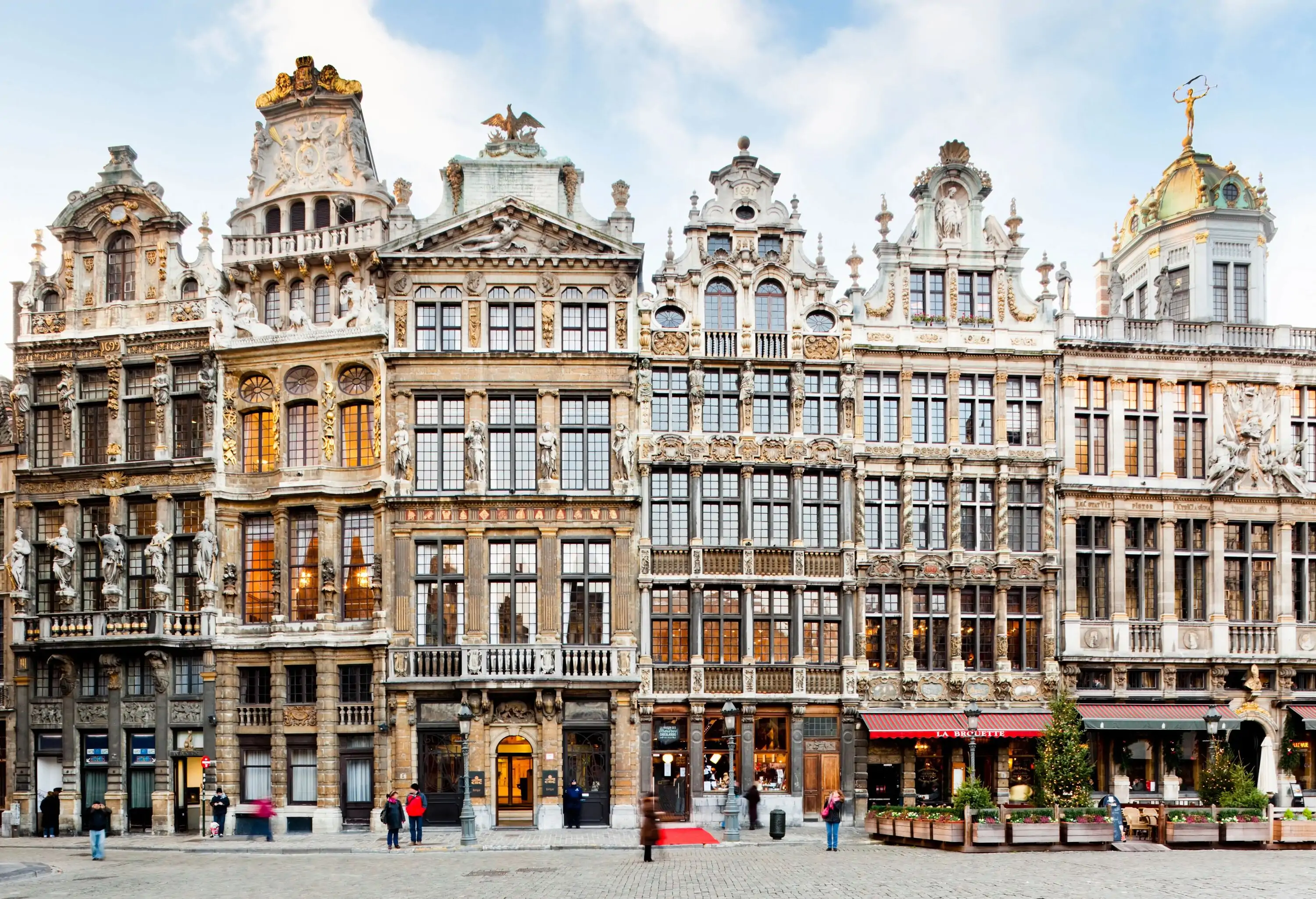 A row of tall medieval buildings lined up along the cobbled street.