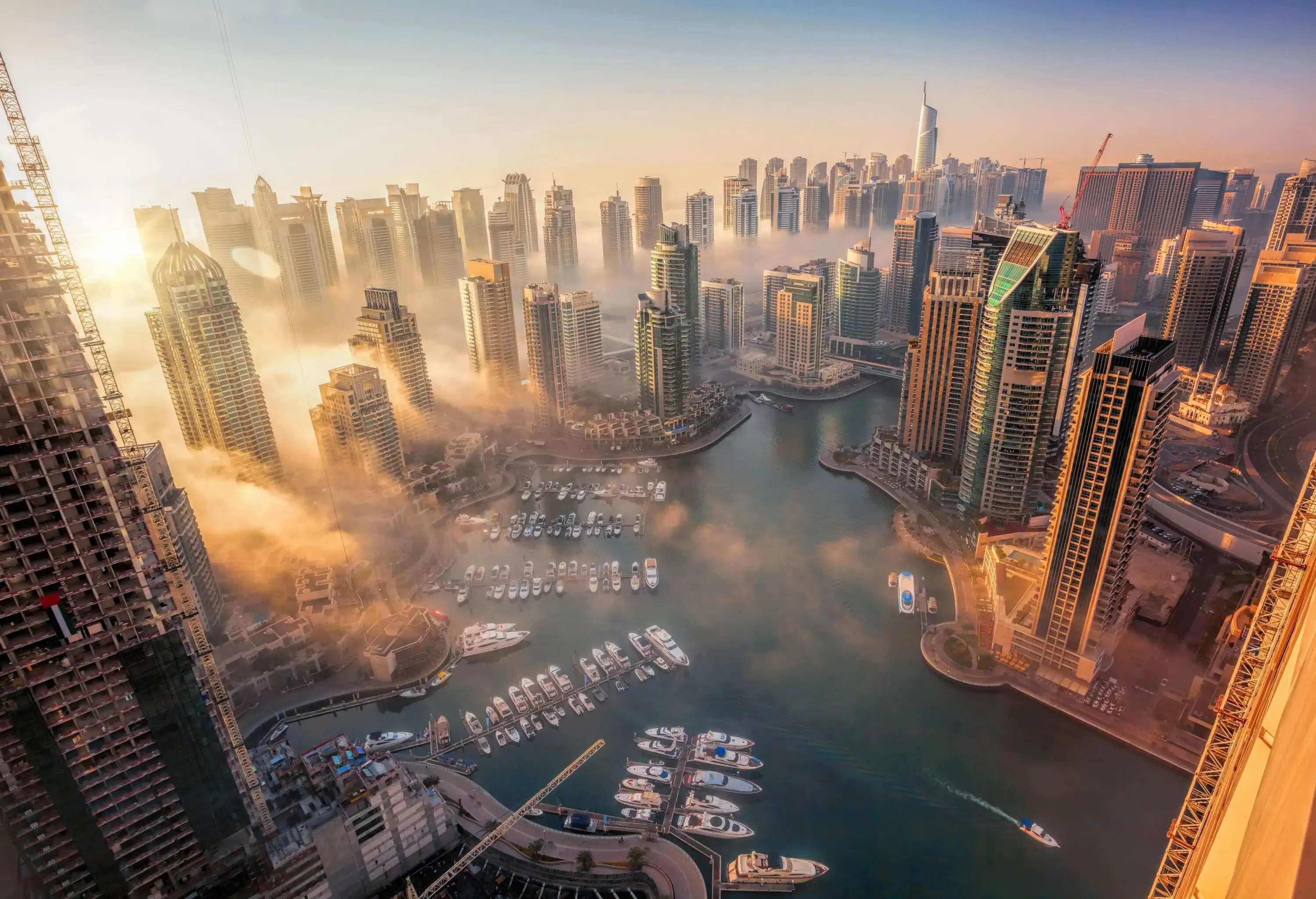 The sun falling over the Dubai Marina and surrounding modern buildings.