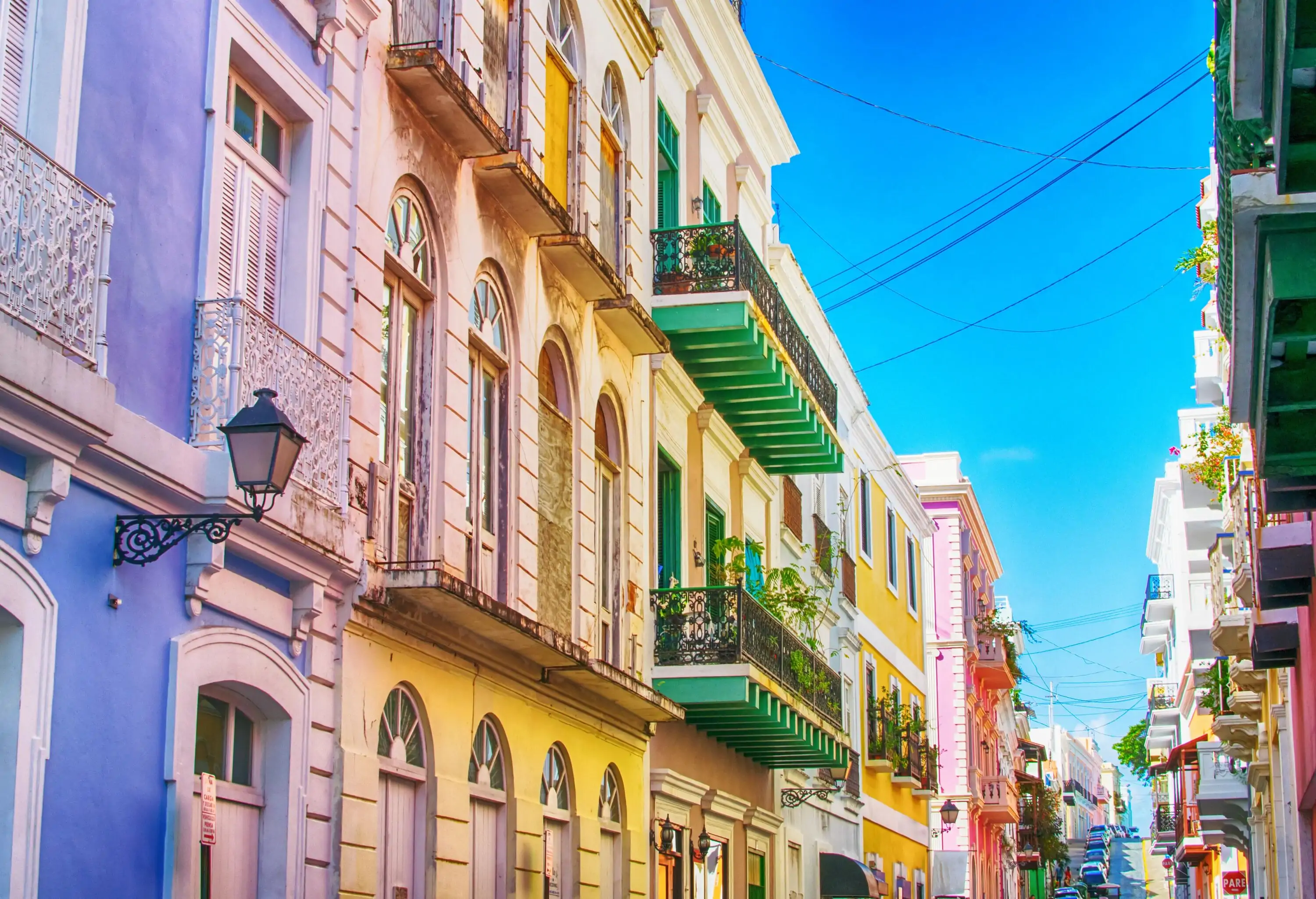 A row of colourful adjacent buildings in a neighbourhood.