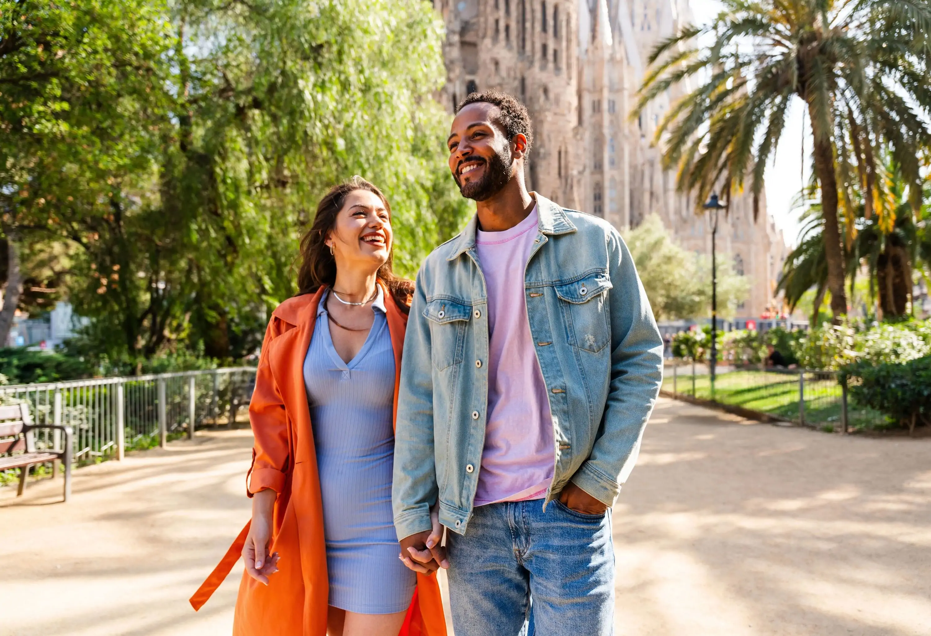 Multiracial beautiful happy couple of lovers dating at Sagrada Familia, Barcelona - Multiethnic tourists travelling in Europe and visiting a city in Spain, concepts about tourism and people lifestyle