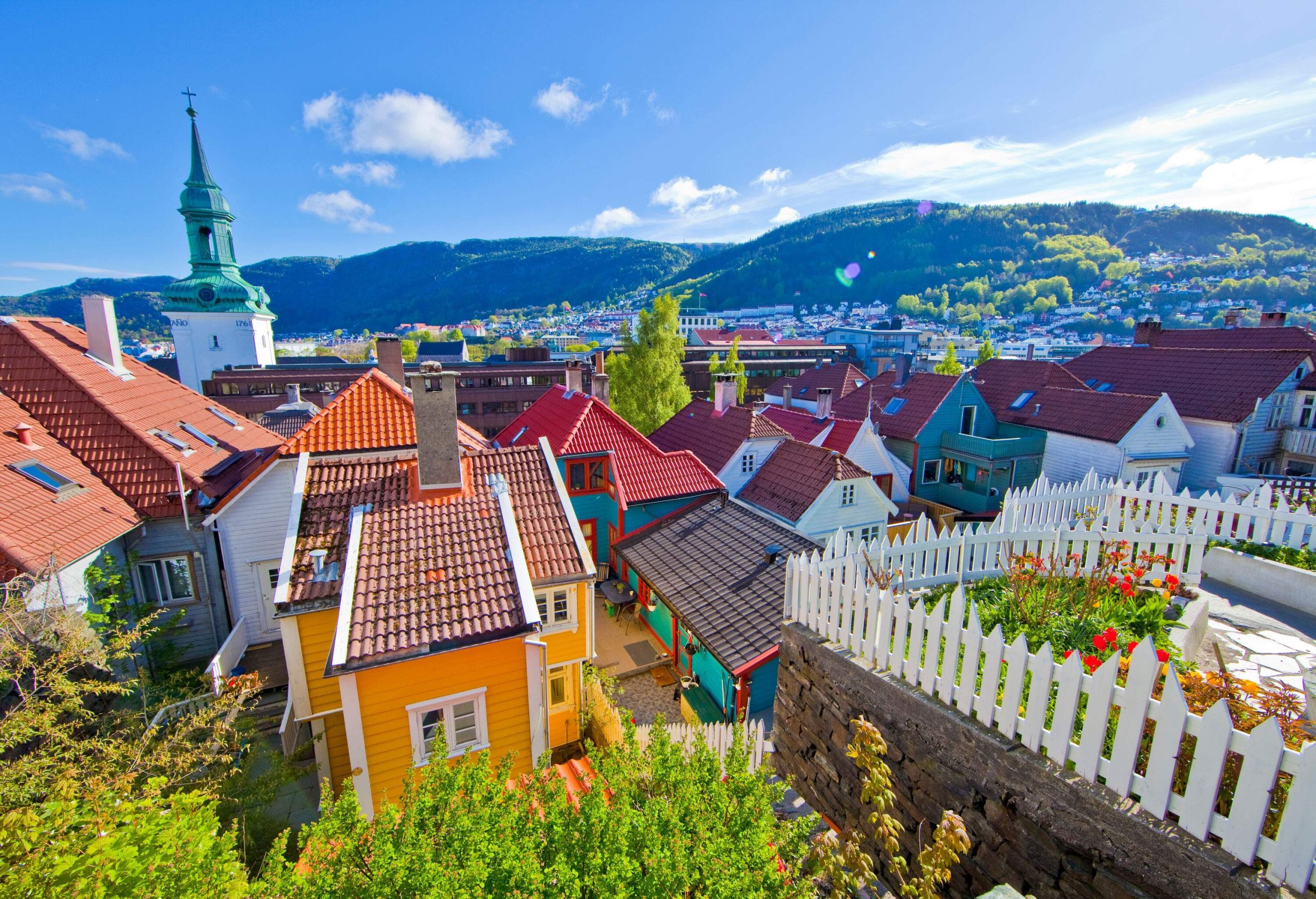 A charming village with a bell tower soaring above the rooftops of colourful houses.