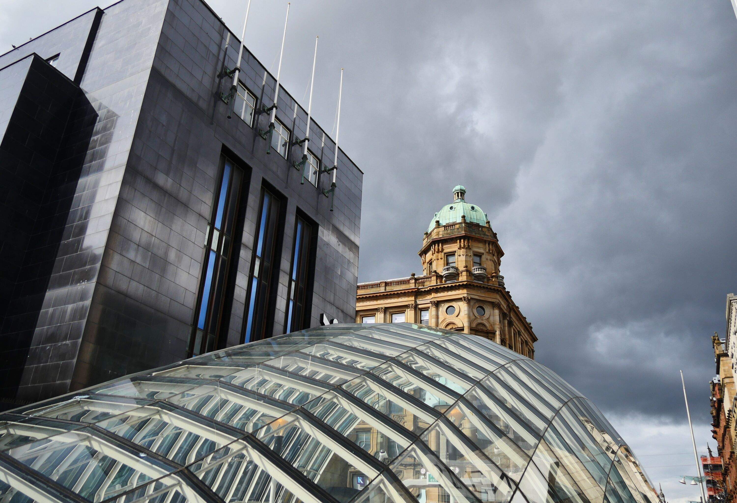 Different building roofs are viewed from a glass dome covering an overcast.