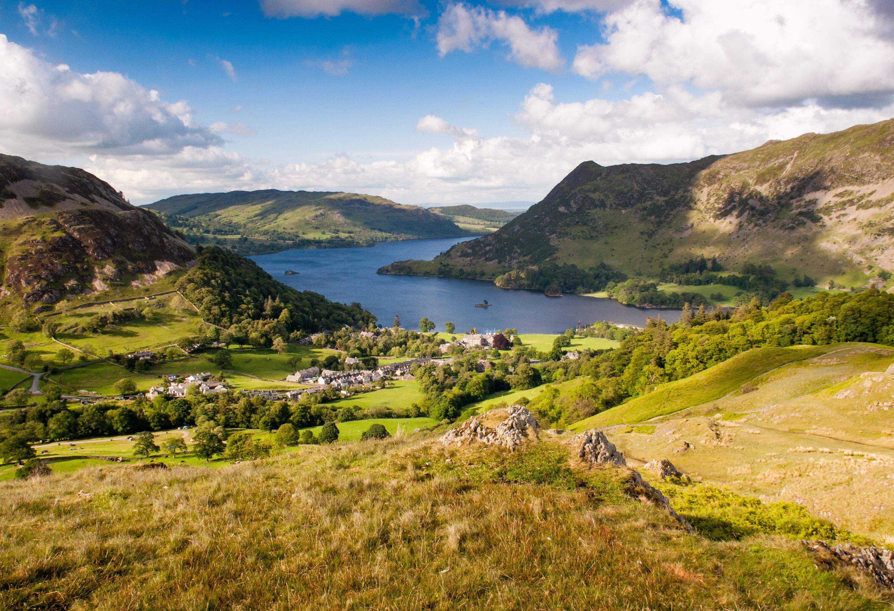 A village on the wooded hills with views of a lake in the valleys.