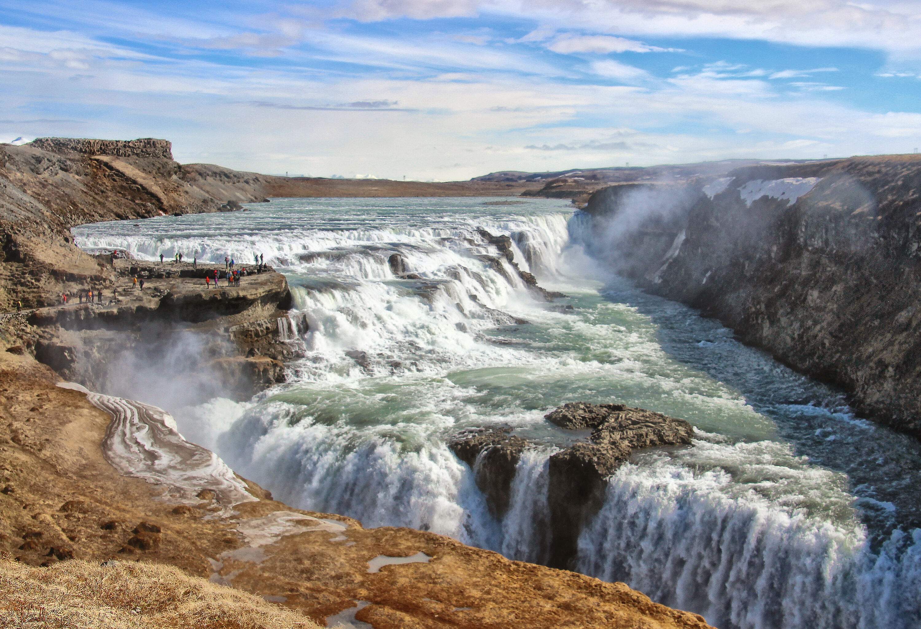 Gullfoss waterfall, a magnificent natural wonder in Iceland, cascades over two tiers of rugged rock formations, creating a stunning display of powerful water currents and mist that takes one's breath away.