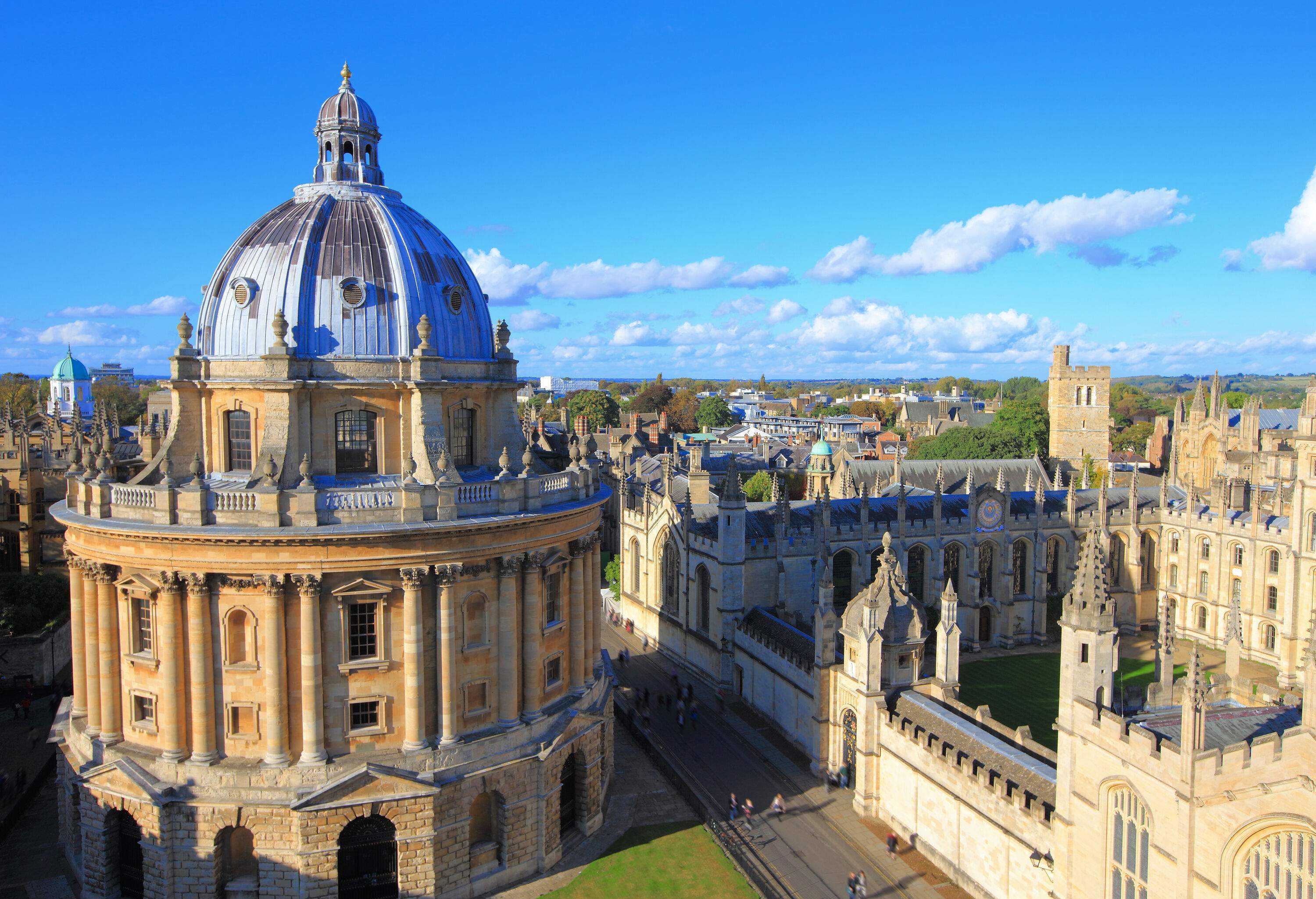 A domed Palladian-style academic library next to a Gothic-style quadrangle college building.