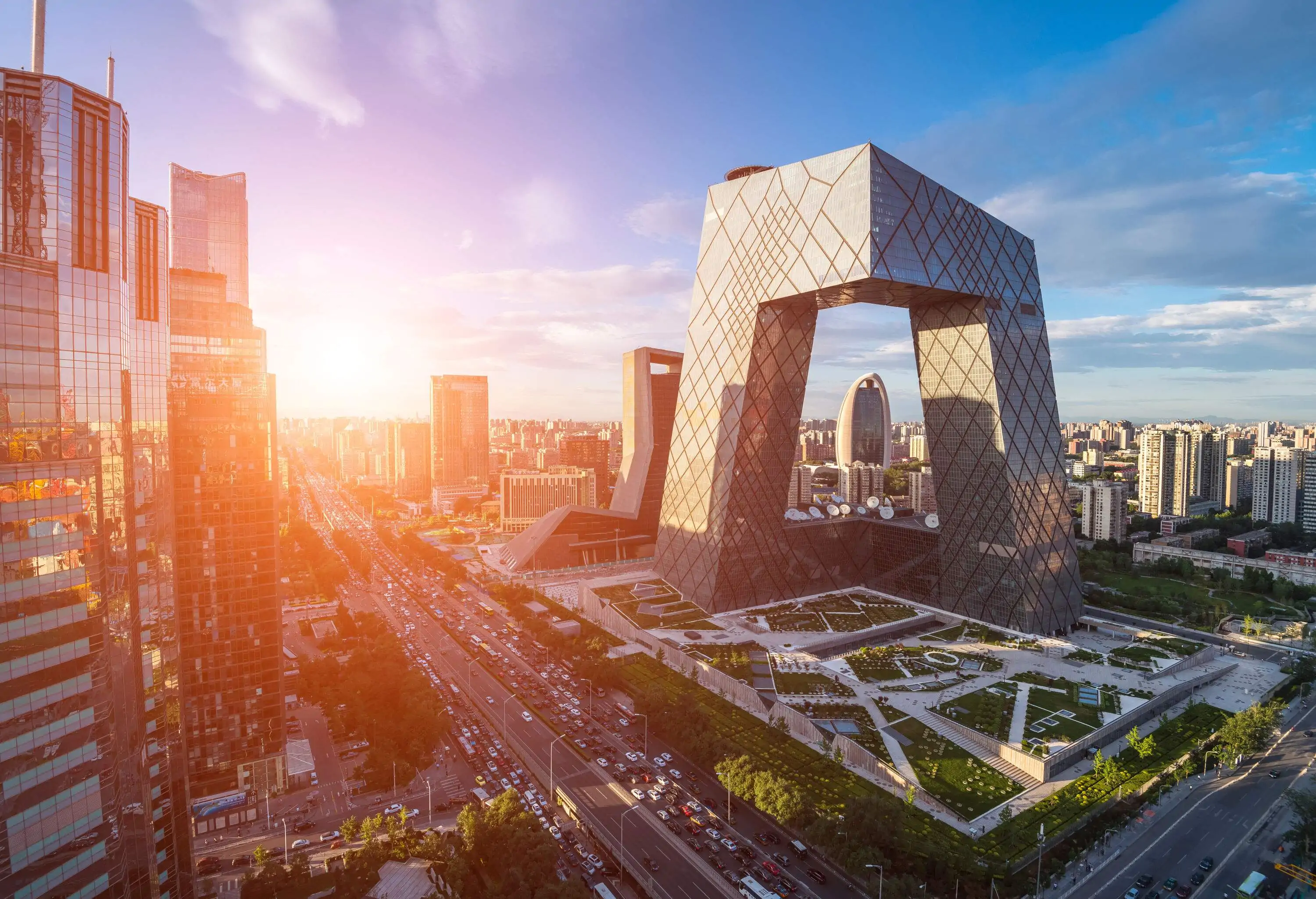 Aerial view of a modern city with futuristic architectured buildings against the scenic sunrise.