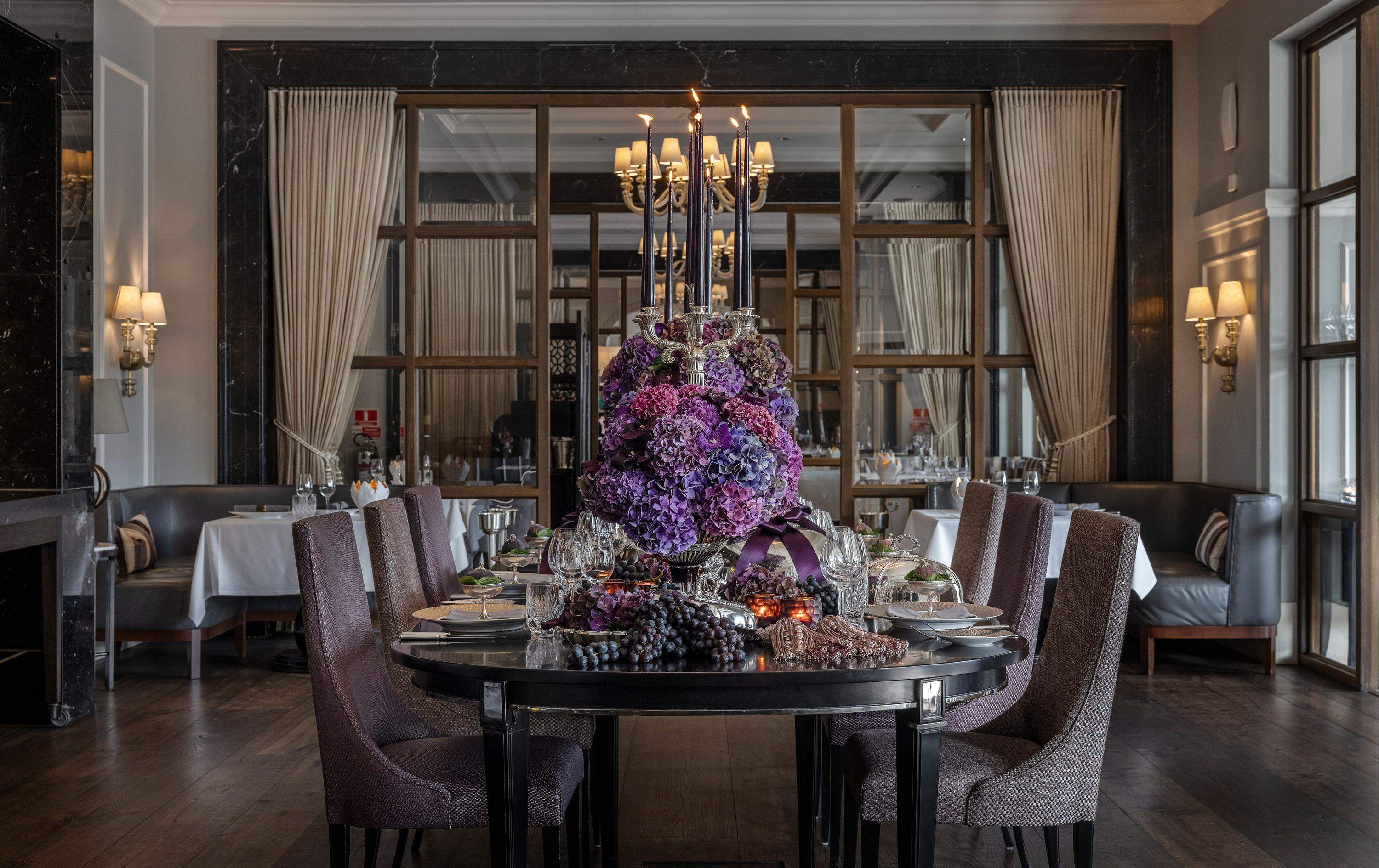 Interior view of hotel restaurant with table set and a vase of purple flowers