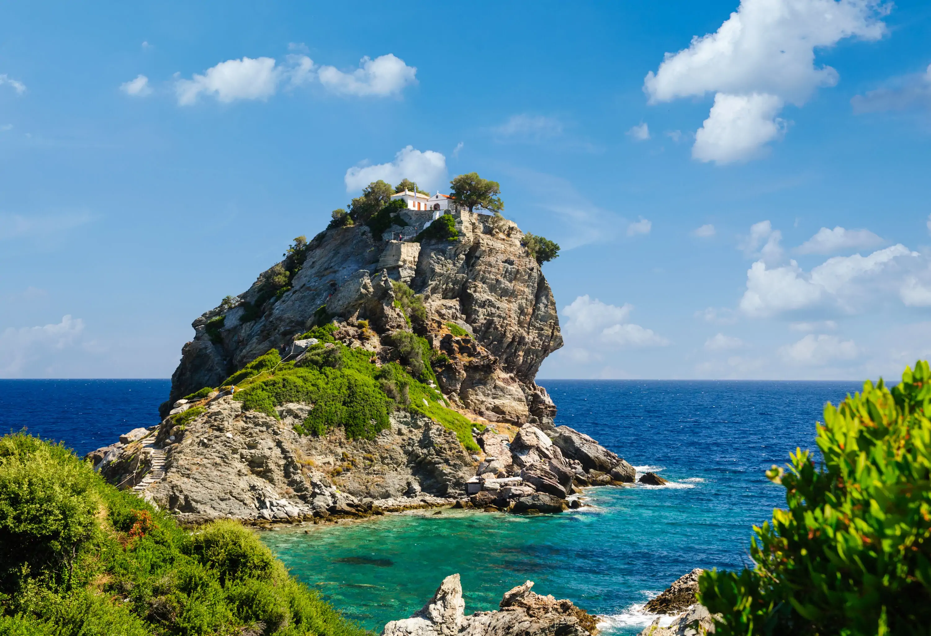 The famous chapel of Agios Ioannis sitting on a rock island with magnificent views of the expansive sea.