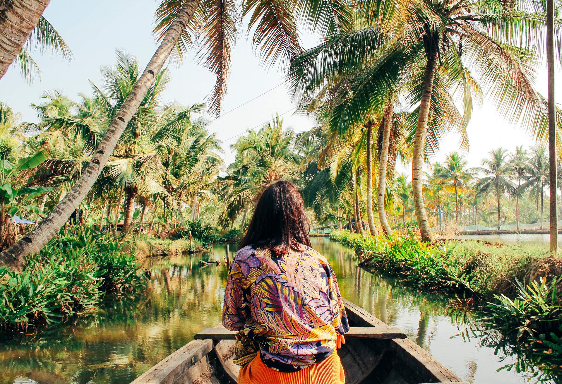 A young woman kayaks through the backwaters of Monroe Island in Kollam District, Kerala, South India.