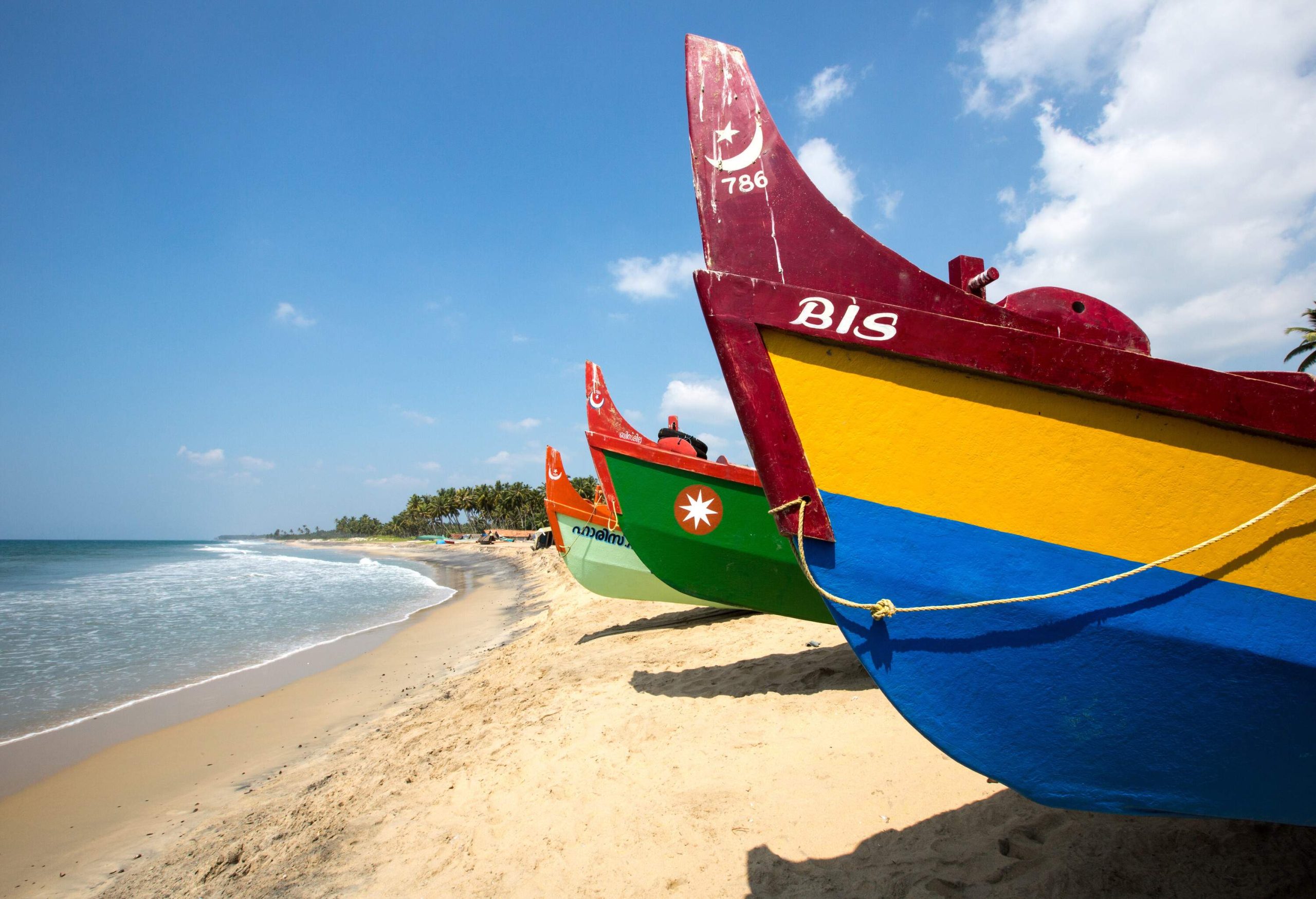 Brightly painted wooden boats docked on the beach.