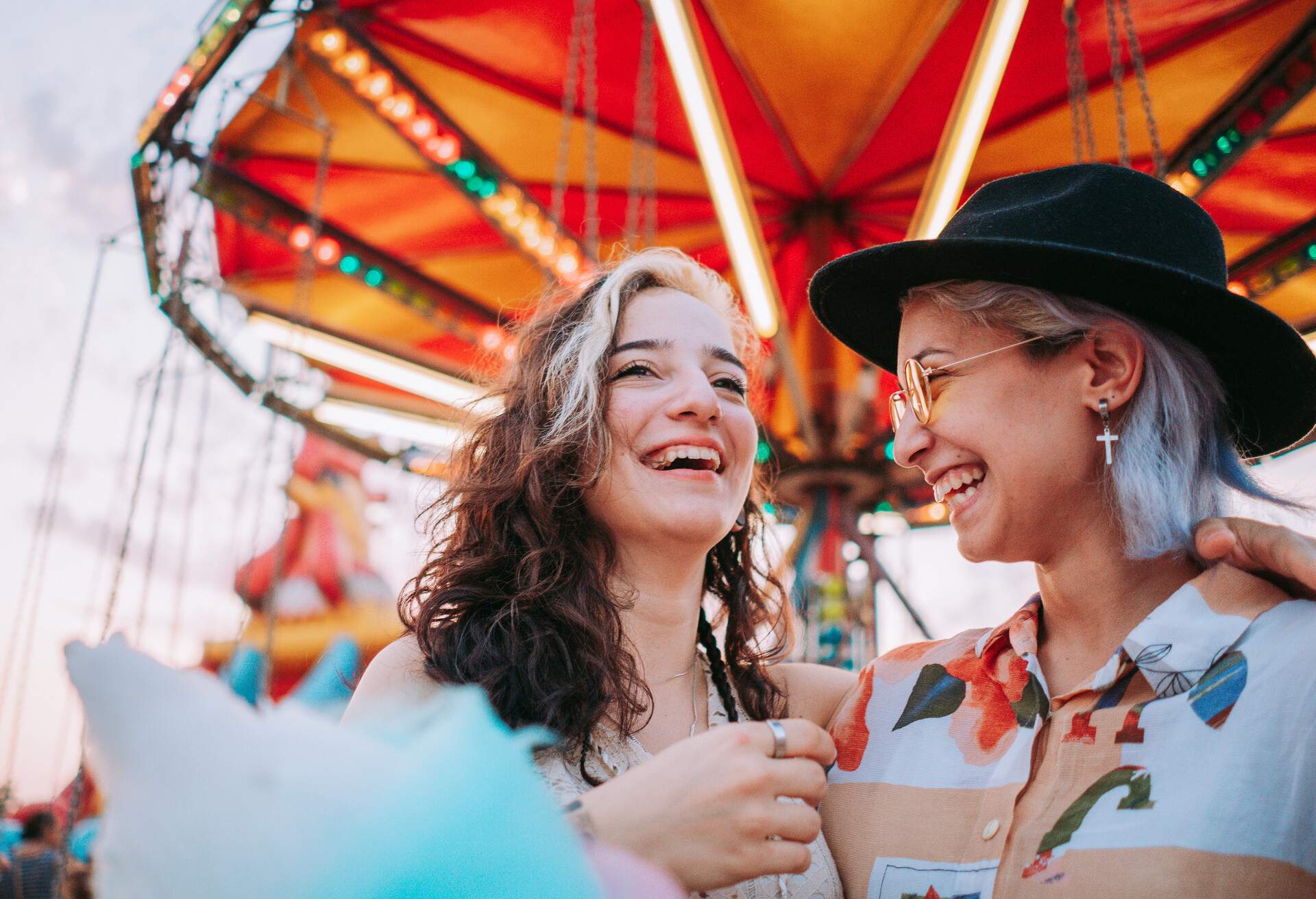 Two women in love smiling at each other at funfair