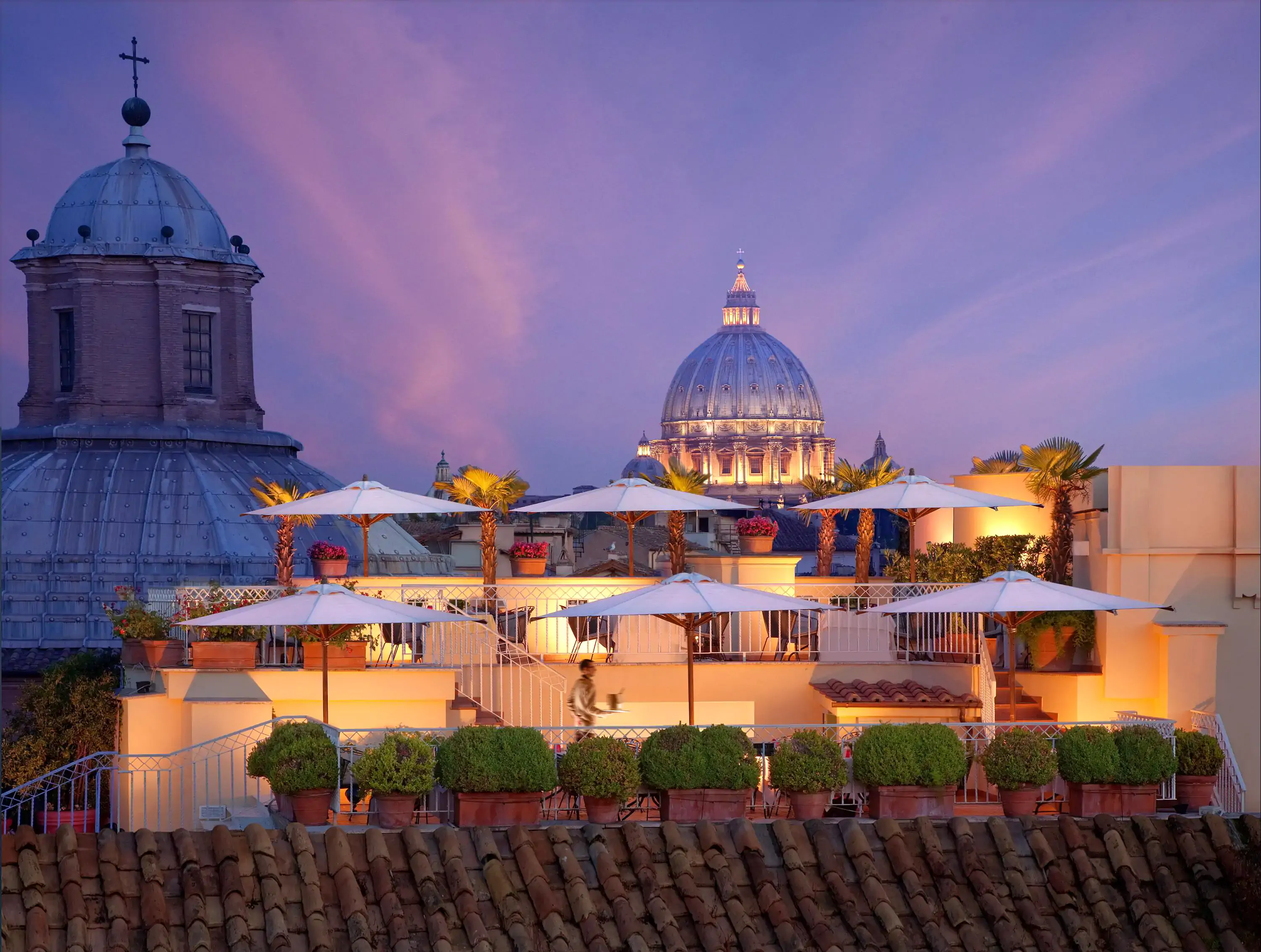 terrace of a luxury hotel at dusk with a view of famous churches and monuments in the background