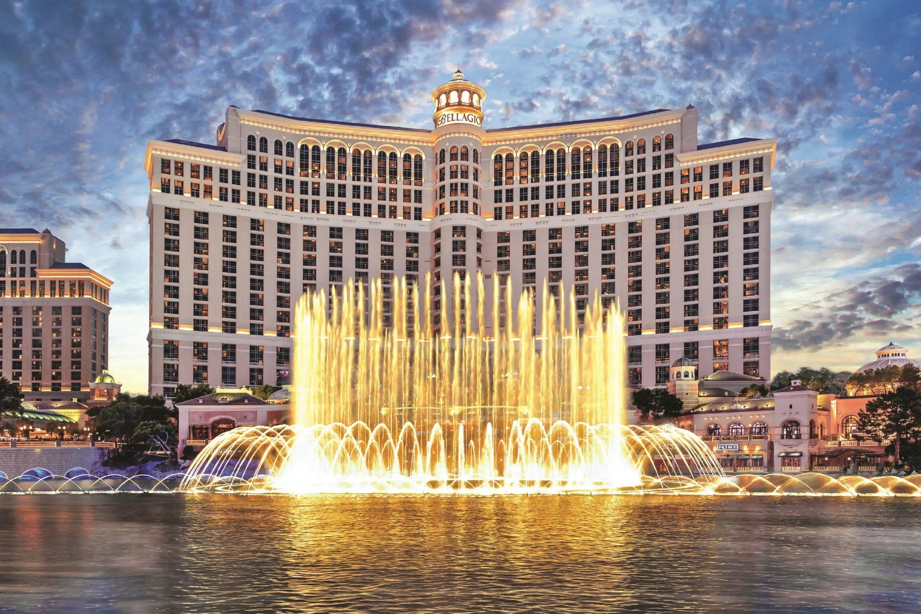 Lit up fountains by large hotel building