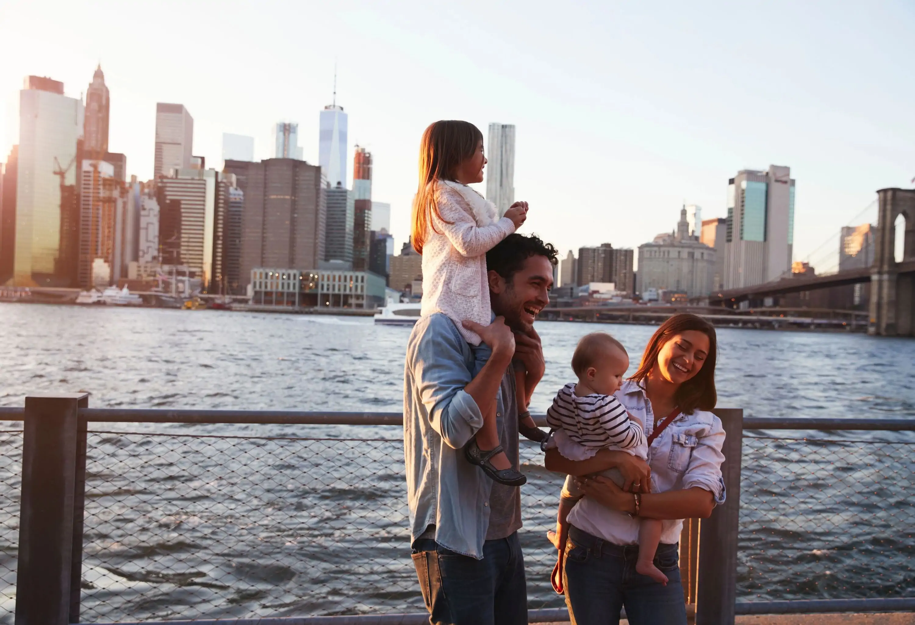 Young family with daughters standing on quayside, side view