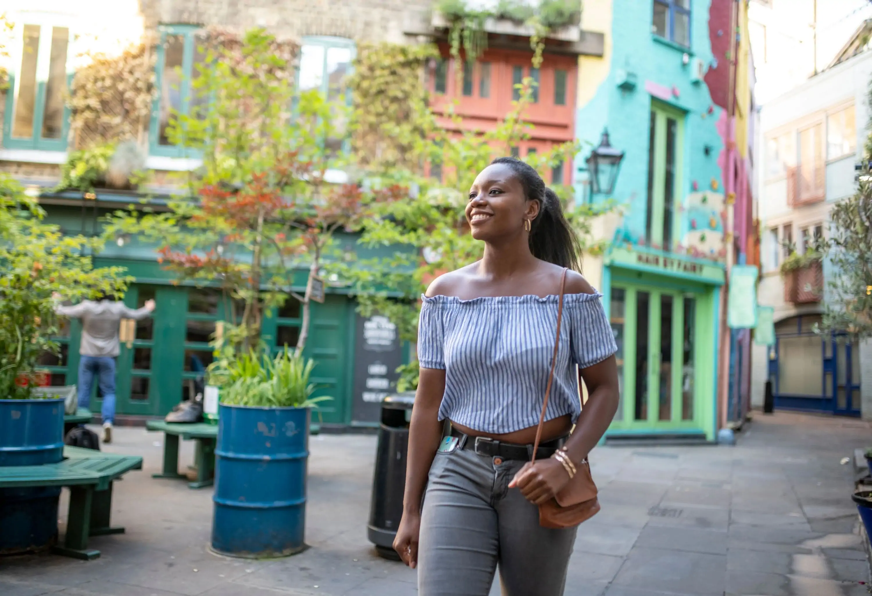 A happy woman on the street with the background of colourful buildings.