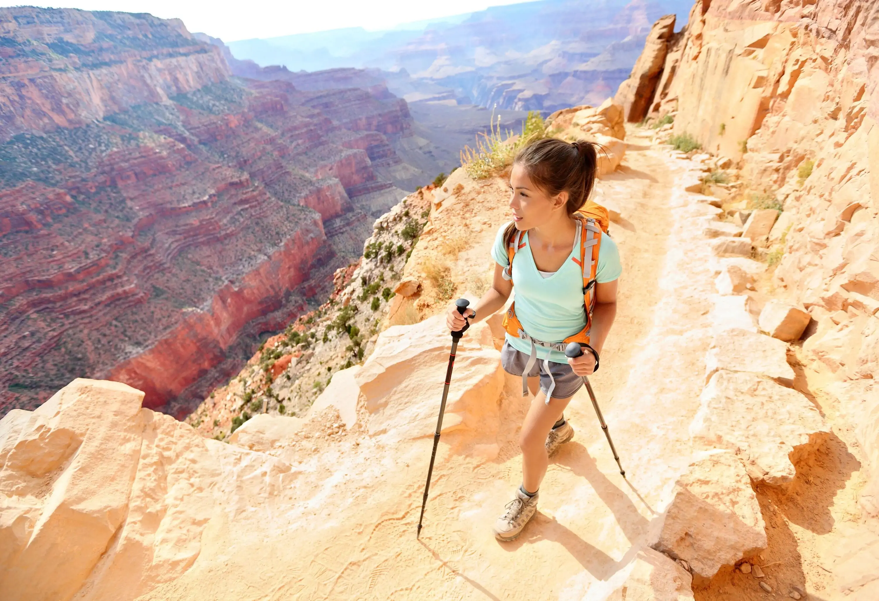 Hiker woman hiking in Grand Canyon walking with hiking poles. Healthy active lifestyle image of hiking young multiracial female hiker in Grand Canyon, South Rim, Arizona,