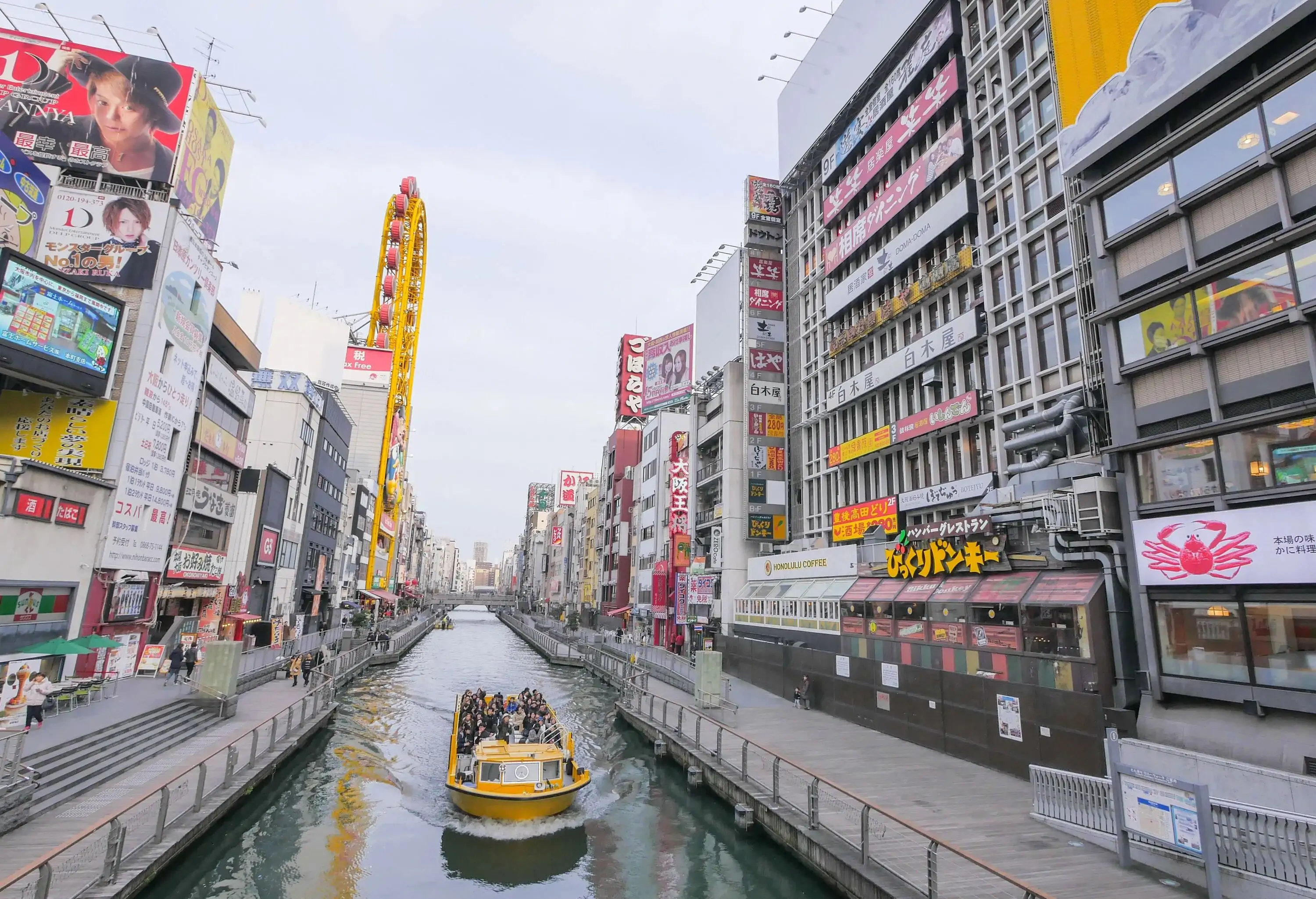 Yellow boat on a canal river in a modern Asian city